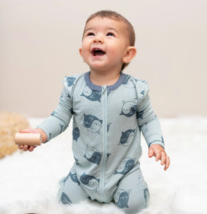 Lifestyle pic of baby wearing a sage green zippered footie with yin-yang seals print
