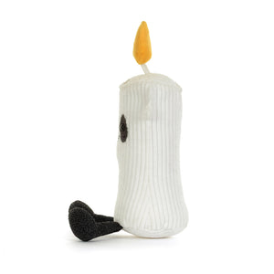 A white ribbed plush candle toy with a yellow flame on top, a small black embroidered eye, and a black textured foot, photographed on a clean white background.