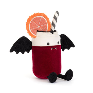 A plush toy shaped like a vampire milk drink cup, featuring a deep red velvet body, a white foam top, black bat wings, a black-and-white striped straw, and a decorative orange slice garnish, photographed on a clean white background.