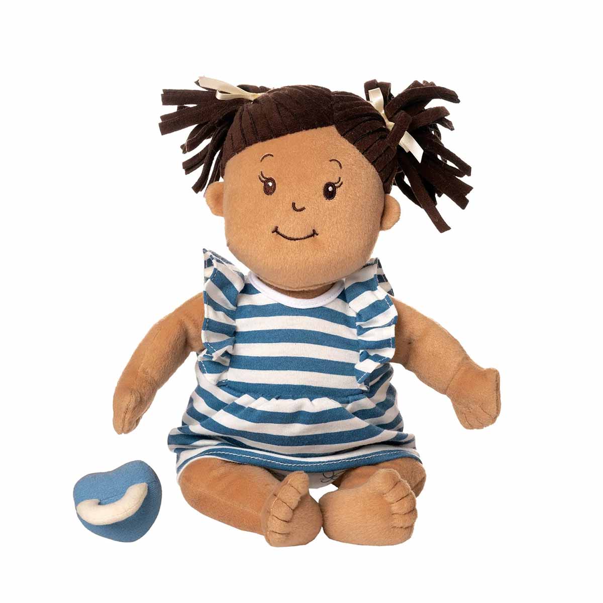 Plush Baby Stella Beige doll with brown pigtails wearing a blue and white striped dress. Blue magnetic pacifier is beside doll. Doll is 15 inches and is sitting facing forwards.