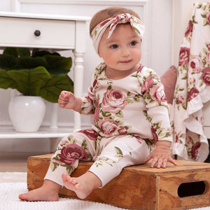 Lifestyle pic of baby wearing romper with cabbage roses all over print.