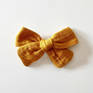 Bohemian Babies. Deep yellow-orange muslin bow on an alligator hair clip. Color Mustard