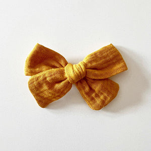 Bohemian Babies. Deep yellow-orange muslin bow on an alligator hair clip. Color Mustard