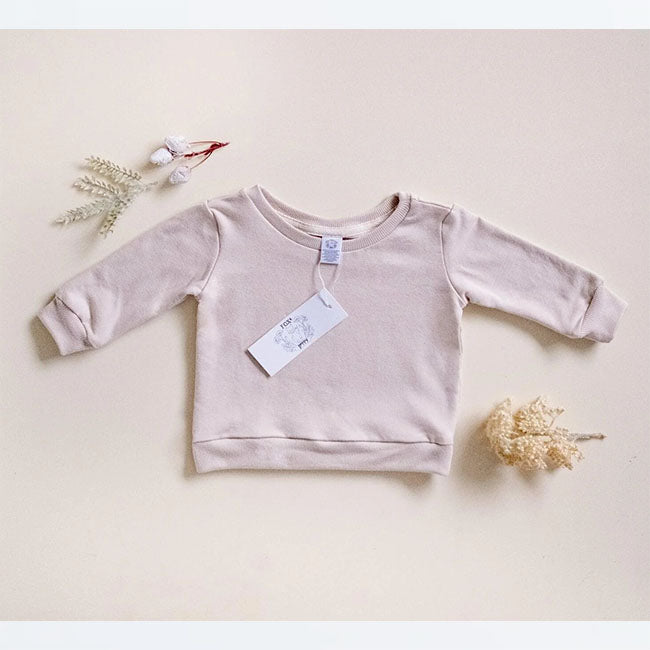 Infant and kids pullover in Oat with cuffs, waistband and seam binding at neck opening for comfort. Tag at beck of neckline.