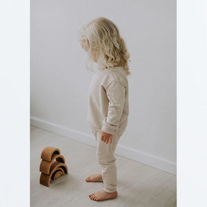 Toddler wearing oat fleece lounge pant and oat fleece pullover in lifestyle pic.
