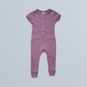 infants short sleeve long leg romper with cuff binding at sleeves and neck. The colour name is Ginger, but it is more of a dusty rose colour. Four snap buttons down front of henley-style top.