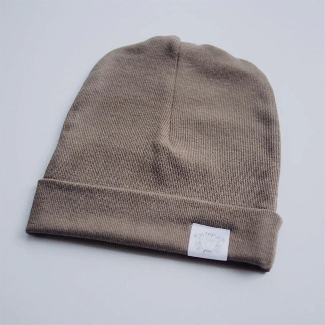 Ribbed cotton bamboo knit hat with foldover edge and fox and poppy logo tag on front edge. Americano brown