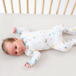 Lifestyle pic of baby in crib wearing Cloud Party print zippered footie.