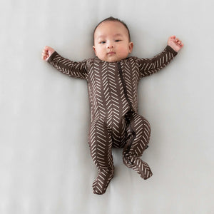 Lifestyle pic of a baby wearing Espresso Herringbone zippered footie.