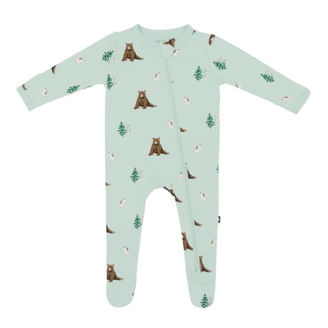 Footie with zipper down front and one leg with zip guard at neck in Trail print. Trail print is a repeating, all-over print featuring a pair of Douglas fir trees, a brown bear sitting down, and a chipmunk on its hind legs, over a pale grey-green background color called Sage