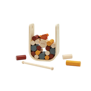 Wooden game with colorful cylindrical pieces and two sticks on a white background