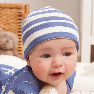 Lifestyle pic of baby wearing navy and white airplane romper with matching beanie in wide navy and white stripes.